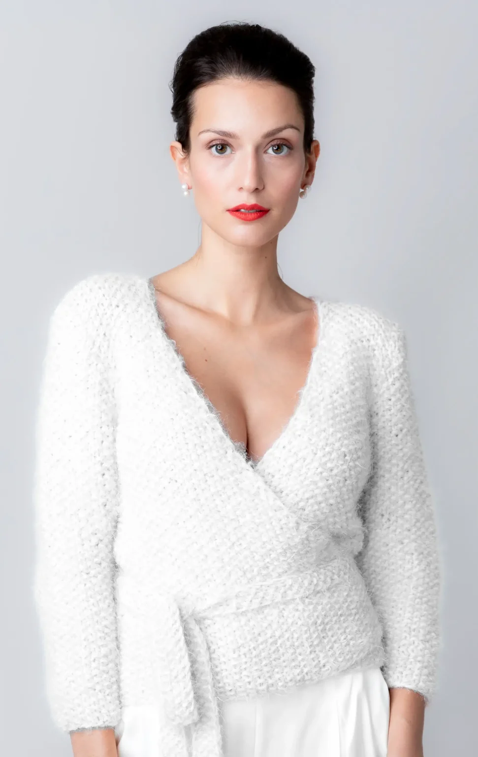 Elegante Ballerina Girl - Pearl Strickjacke in ivory, elegant kombiniert mit einem tiefen V-Ausschnitt.