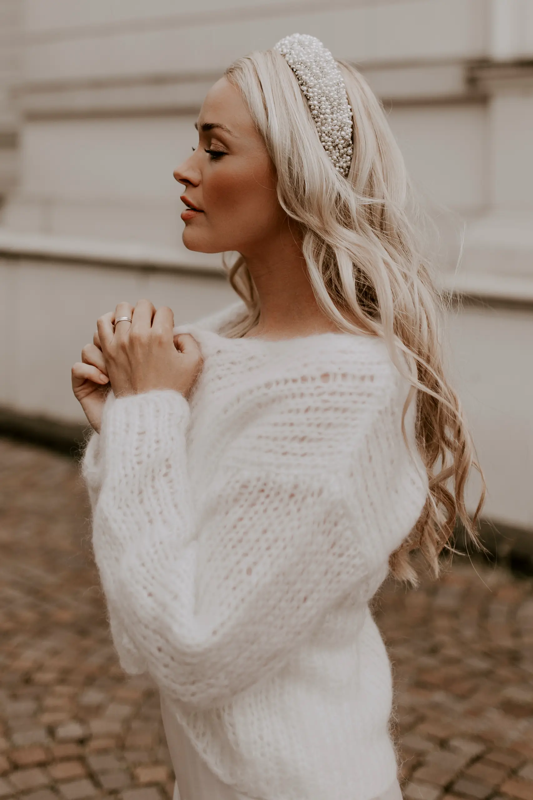 Eine Braut trägt den kuscheligen Brautcardigan FLUFFY FLEUR in der Farbe Ivory.