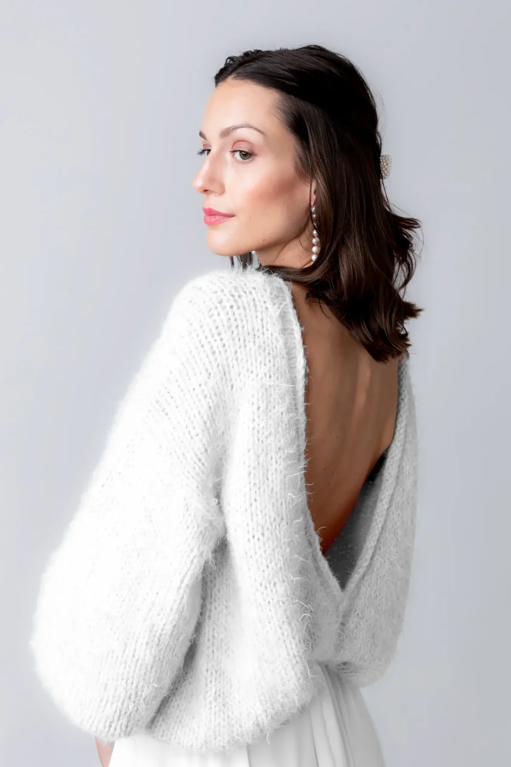 Modell trägt den cosy rosie oversized Brautpullover mit tiefem Rückenausschnitt.